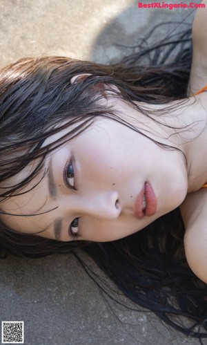 A young woman sitting on the grass in a park.