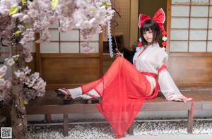 A woman in a red and white kimono posing for a picture.