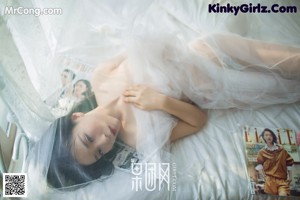 A woman in a pink lingerie posing on a bed.