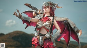 A woman dressed as a dragon holding a fire in her hand.