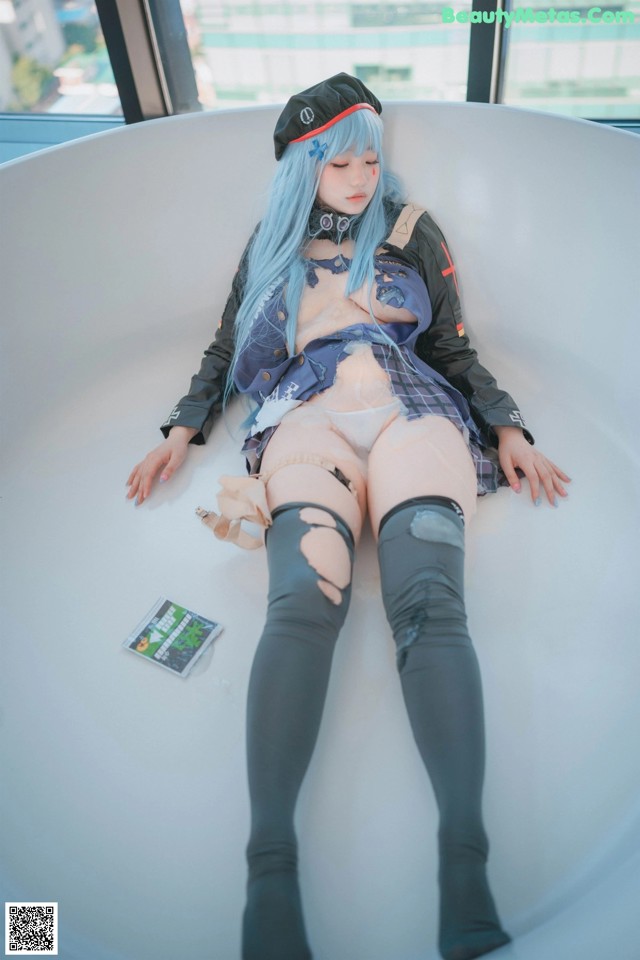 A woman with blue hair is sitting in a bathtub.