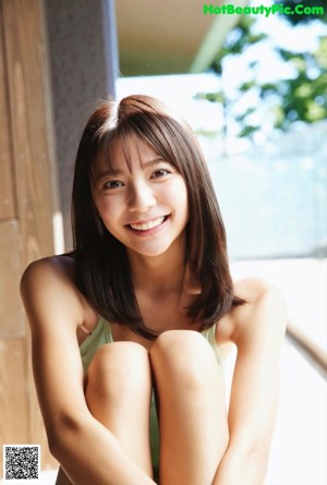 A woman in a green headband is posing on a couch.