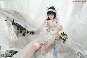 A woman in a wedding dress holding a bouquet of flowers.