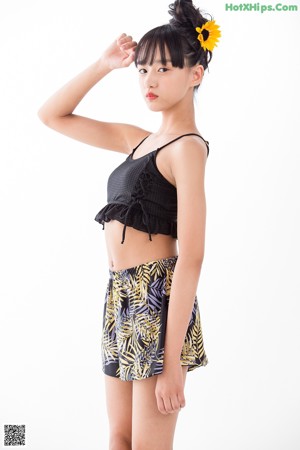 A woman in a black top and a yellow and black skirt.