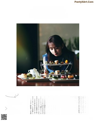 A woman sitting at a table with a glass of wine.