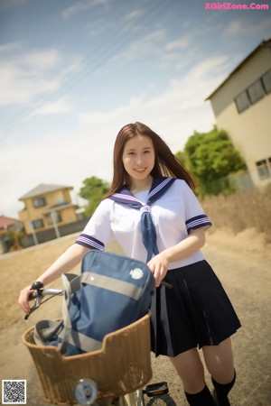 A woman in a school uniform is posing for a picture.