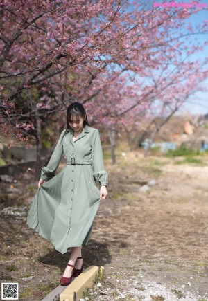A woman in a green dress is standing in the air.