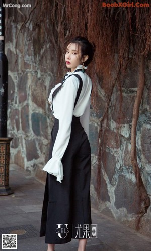 A woman sitting on the steps of a building wearing blue boots.