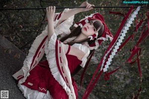 A woman in a red and white dress holding a sword.