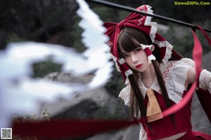 A woman in a red and white dress holding a stick.