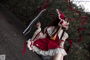 A woman in a red and white dress holding a fan.