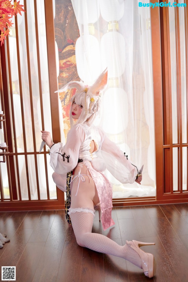 A woman in a bunny costume sitting on the floor.