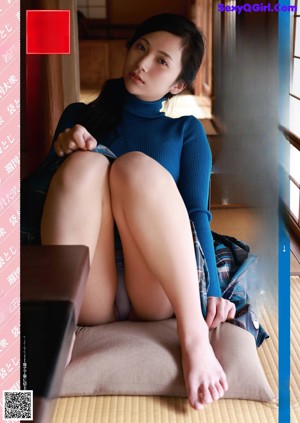 A naked woman standing in a bathroom next to a window.