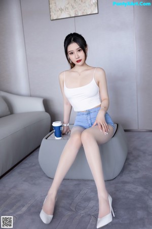 A woman sitting on top of a white couch.