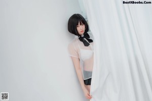 A woman in a white shirt and black skirt posing for a picture.