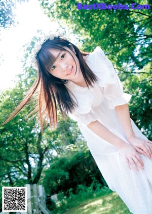 A woman in a white dress posing for a magazine cover.