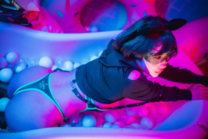 A woman sitting on an inflatable donut in a bathtub.